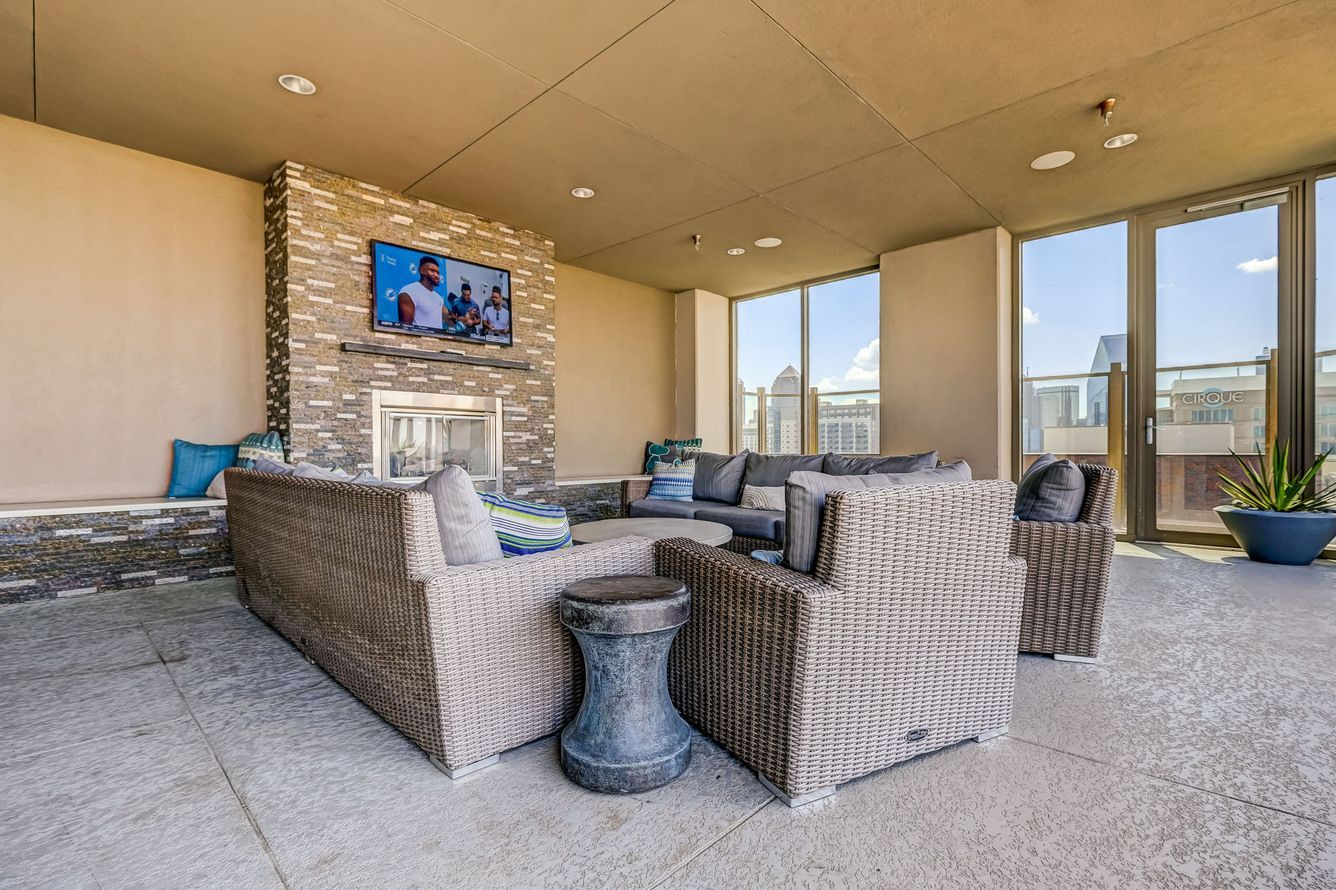 A living room with a fireplace , couch , chairs and a television.