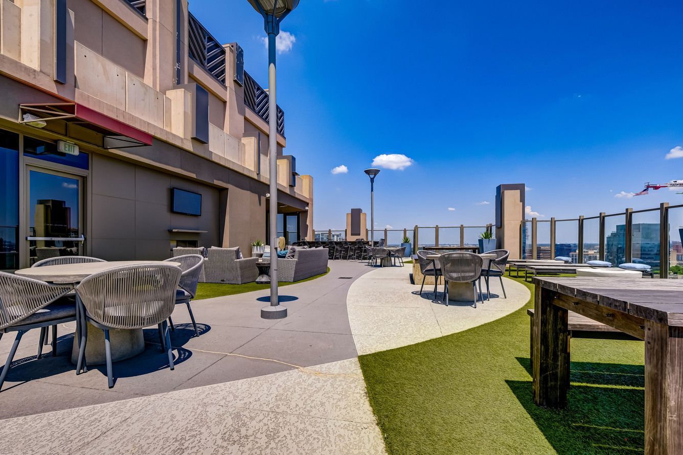 There are tables and chairs on the roof of a building.