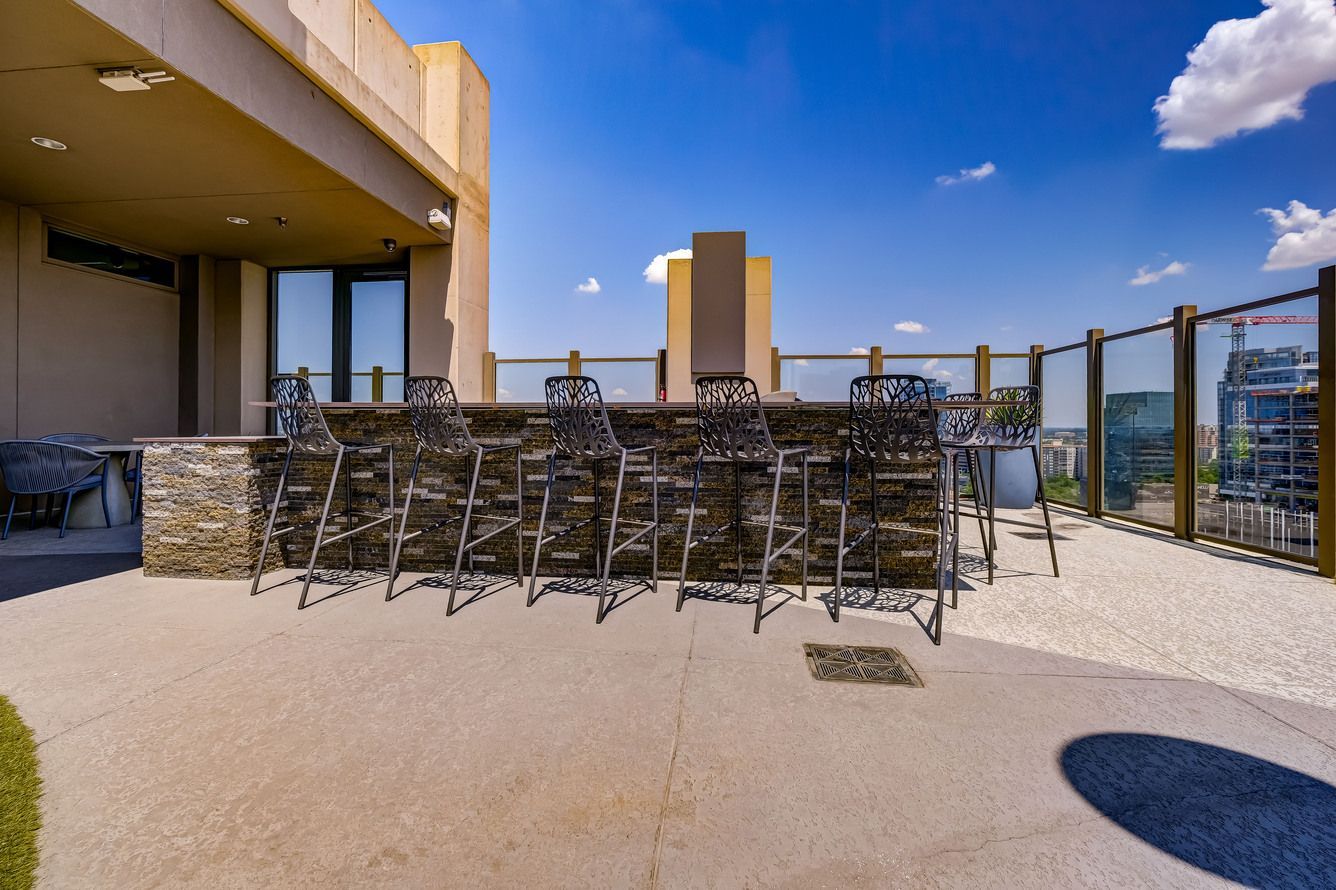 A patio with a bar and chairs on it