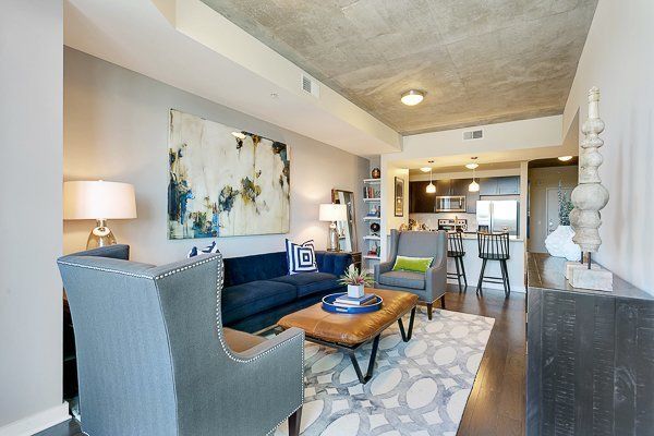 A living room with a couch , chairs , coffee table and a painting on the wall.