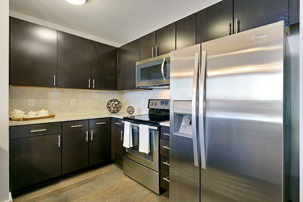 A kitchen with stainless steel appliances , including a refrigerator and microwave.