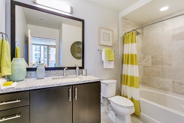 A bathroom with a toilet , sink , mirror and bathtub.