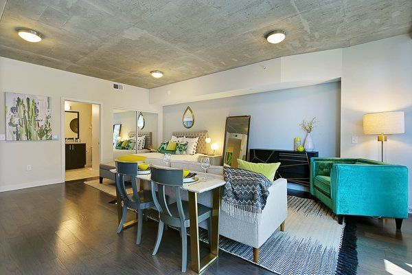 A living room with a dining table , chairs , and a bed.