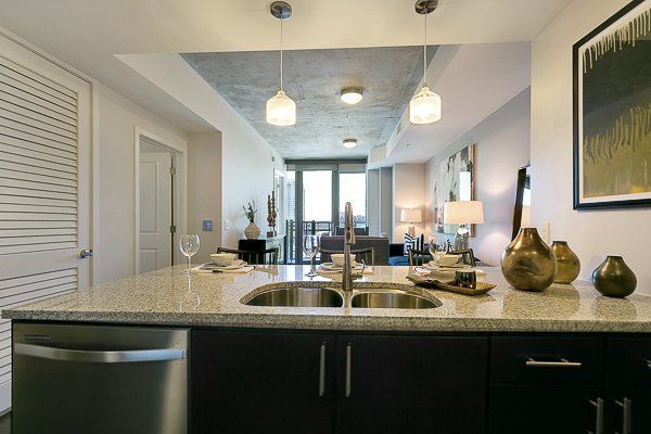 A kitchen with two sinks , a dishwasher , and a picture on the wall.