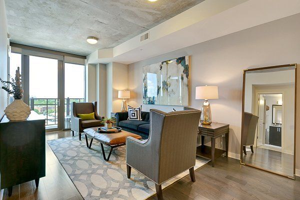 A living room with a couch , chairs , coffee table and a large mirror.