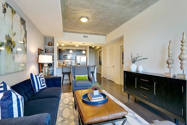 A living room with a couch , chair , coffee table and dresser.