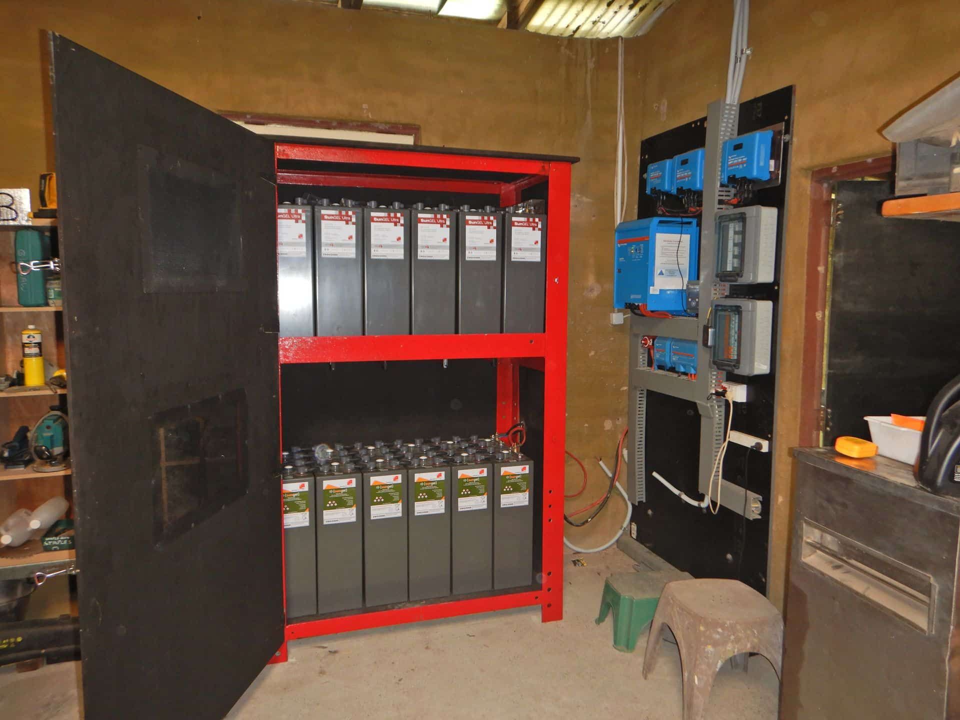 A Room With A Red Cabinet Filled With Batteries — PASMA Electrical In Portsmith, QLD
