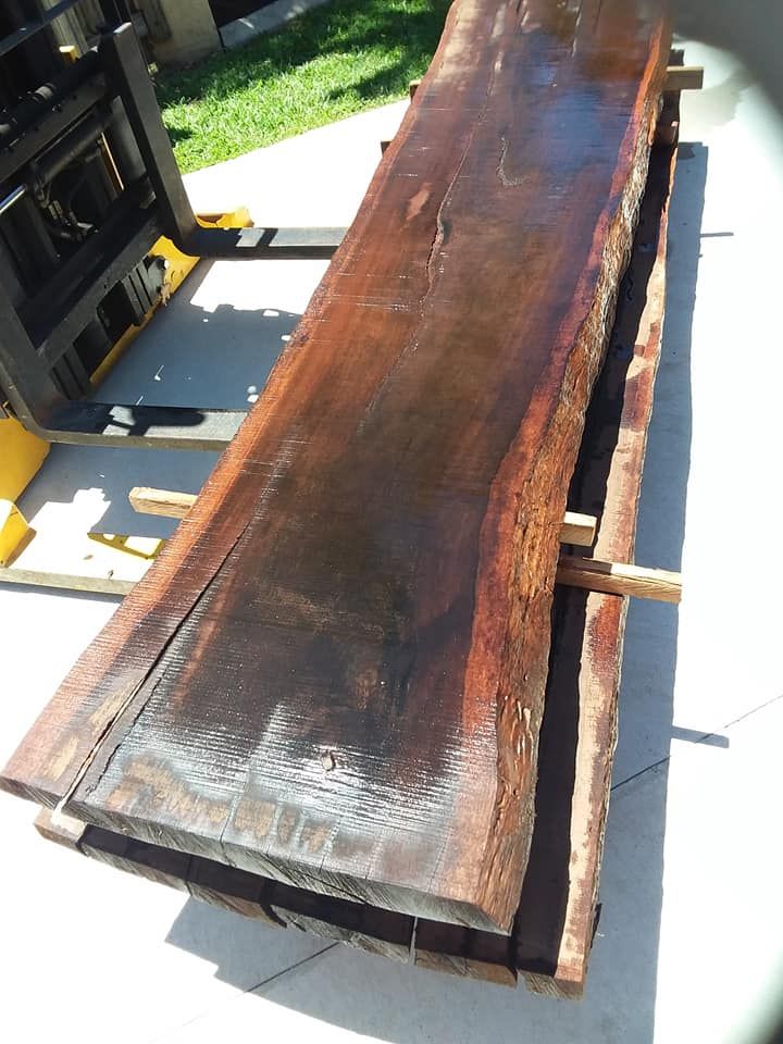 A Large Piece of Wood is Being Lifted by a Forklift — Mackay Hardwood Sales in Cannonvale, QLD