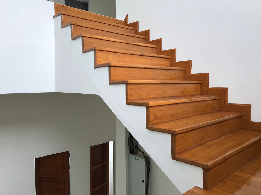 A Wooden Staircase With a White Railing in a House — Mackay Hardwood Sales in Cannonvale, QLD