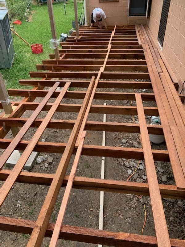 A Man is Working on a Wooden Deck Under Construction — Mackay Hardwood Sales in Freshwater Point, QLD