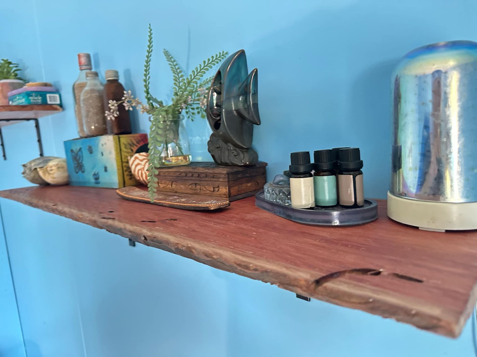 A Wooden Shelf With Bottles of Essential Oils on It — Mackay Hardwood Sales in Freshwater Point, QLD