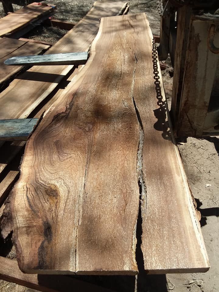 A Large Piece of Wood is Sitting on Top of a Pile of Wood — Mackay Hardwood Sales in Moranbah, QLD