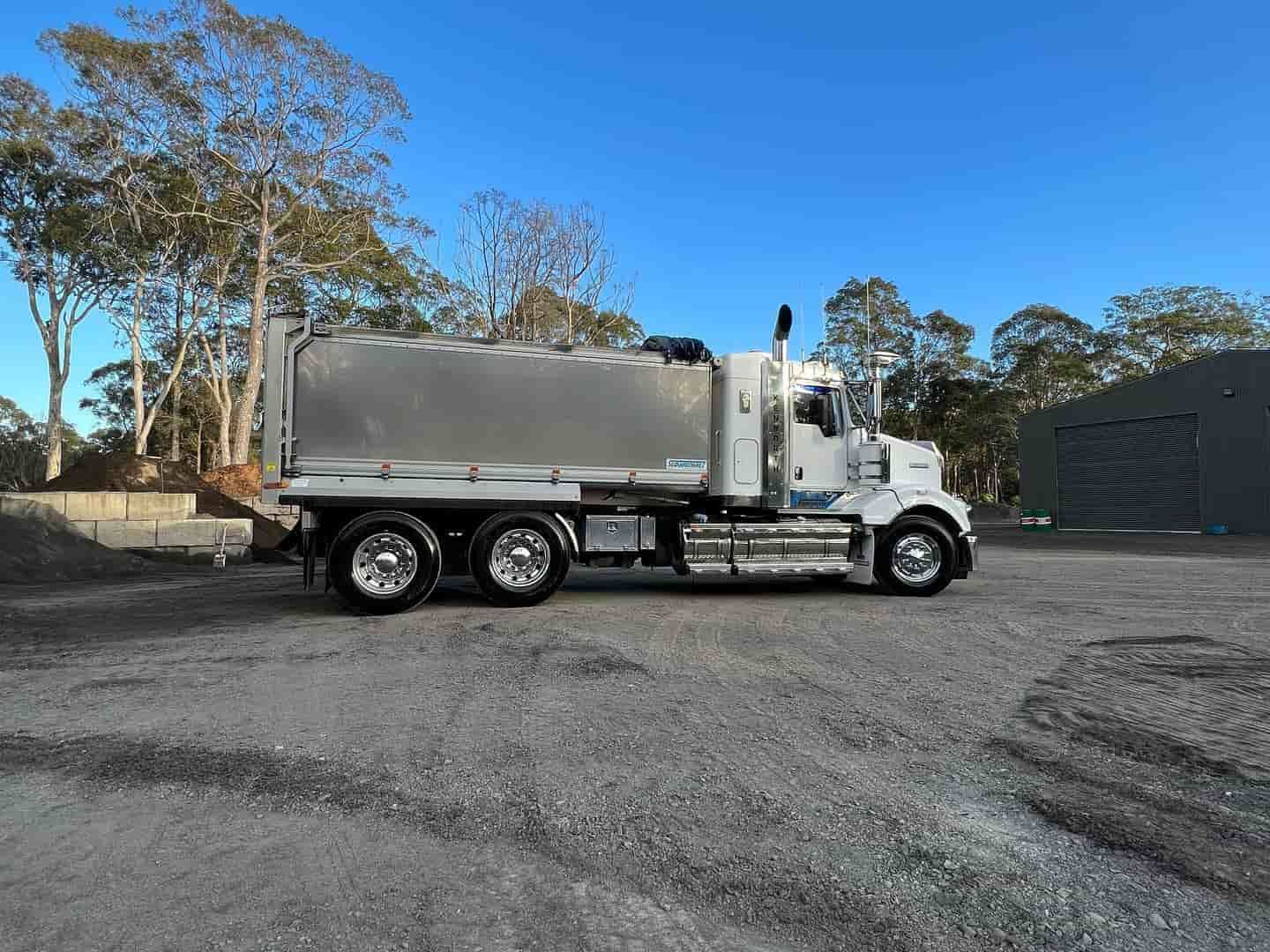 A White Semi Truck Is Parked In A Gravel Lot — JMAK Haulage & Landscapes Supplies In Falls Creek, NSW