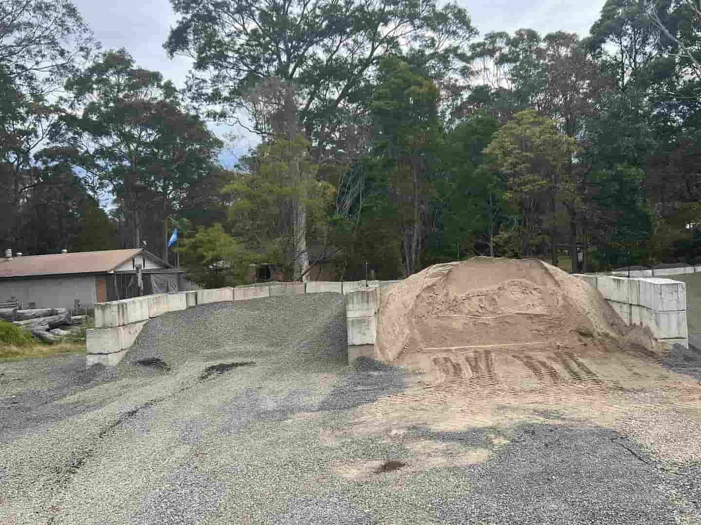 A Pile Of Gravel Is Sitting On Top Of A Dirt Road — JMAK Haulage & Landscapes Supplies In Gerringong, NSW