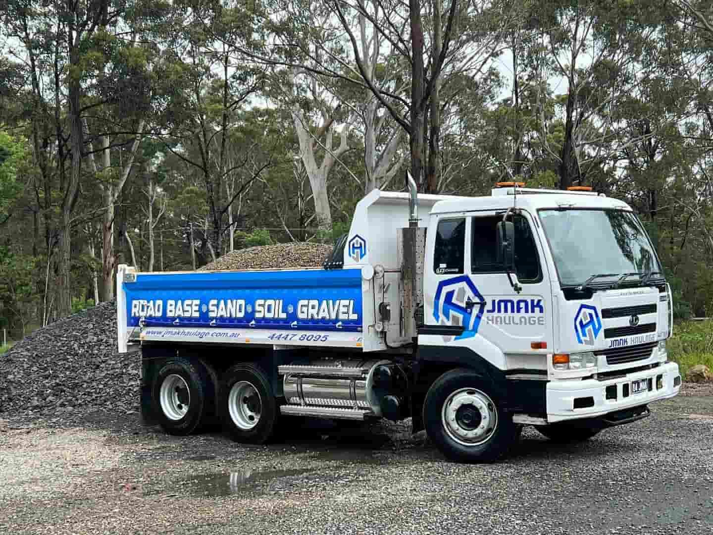 A Dump Truck Is Parked Next To A Pile Of Gravel — JMAK Haulage & Landscapes Supplies In Ulladulla, NSW