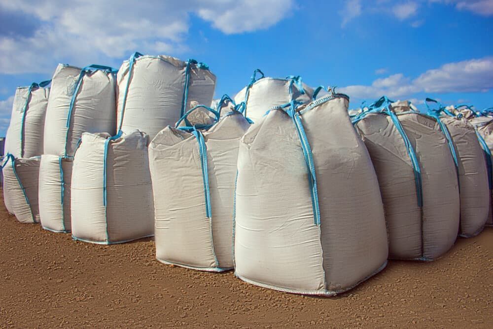 A Bunch Of Bags Are Stacked On Top Of Each Other On A Dirt Field — JMAK Haulage & Landscapes Supplies In Falls Creek, NSW