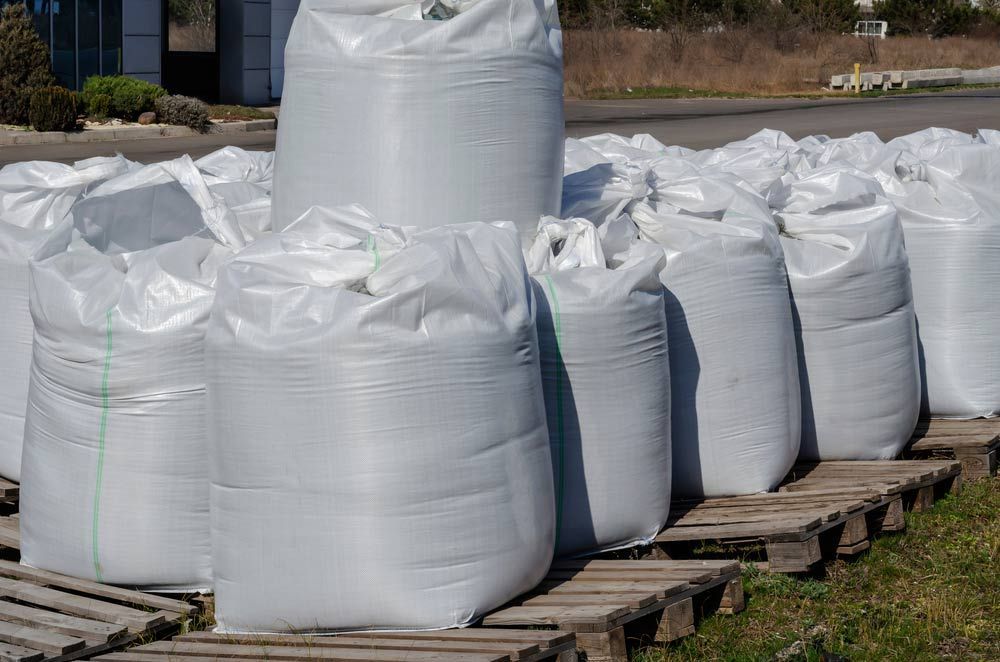 A Bunch Of Bags Sitting On Top Of Wooden Pallets — JMAK Haulage & Landscapes Supplies In Vincentia, NSW