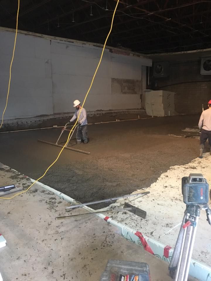 Un groupe d'ouvriers du bâtiment travaillent sur un sol en béton.