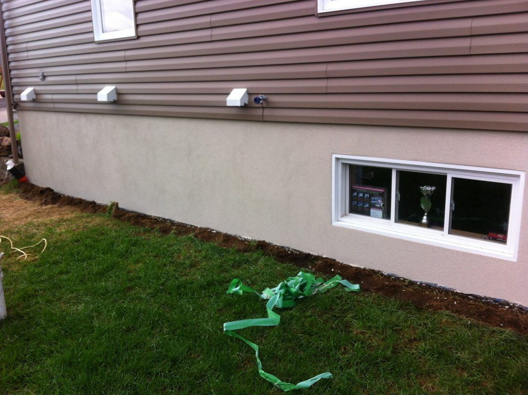 Une maison avec une fenêtre et un ruban vert devant.