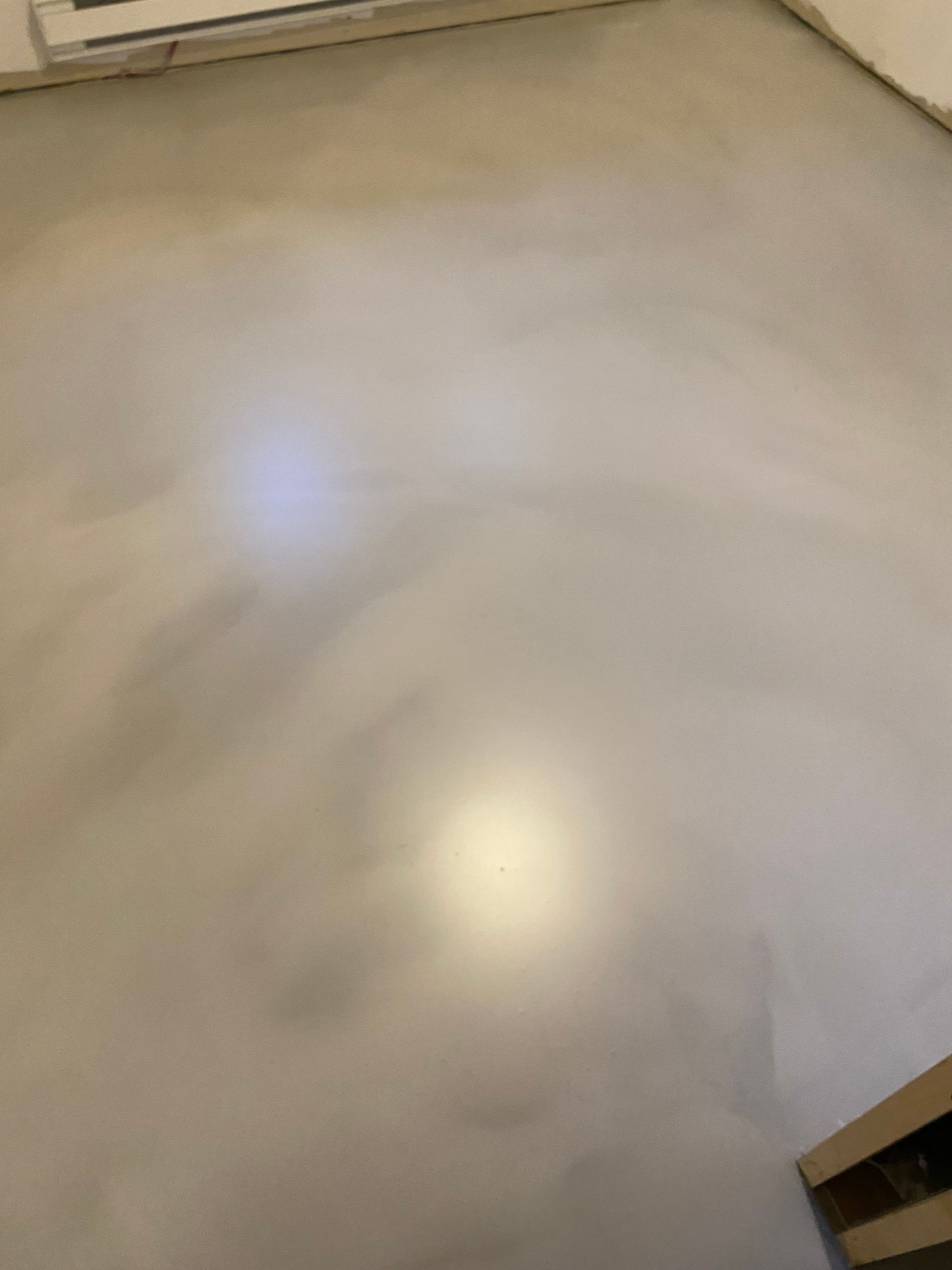 Un gros plan d'un sol en béton avec une lumière qui brille dessus.