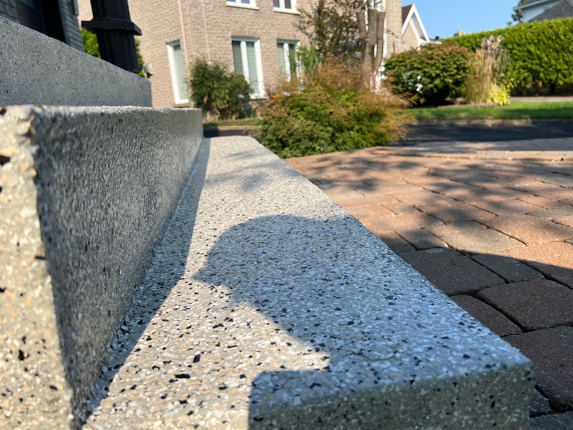 Un gros plan d'un escalier en béton avec une maison en arrière-plan