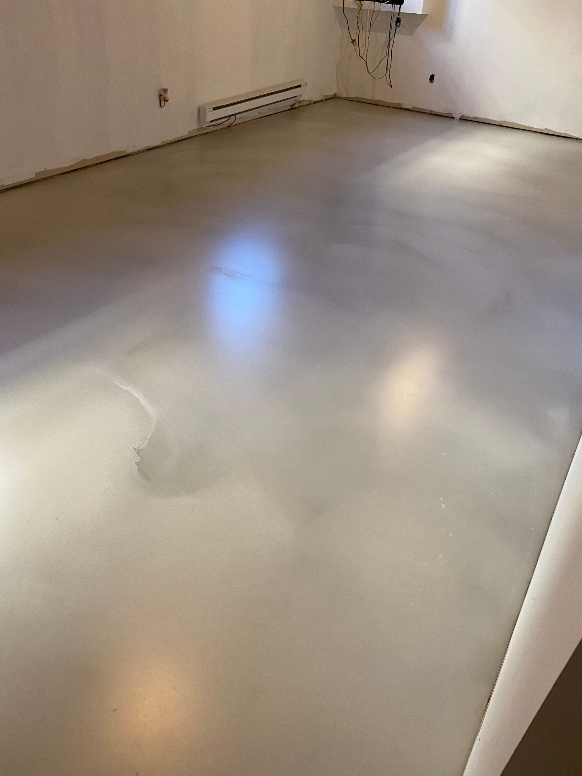 Une pièce avec un sol blanc et des murs blancs.