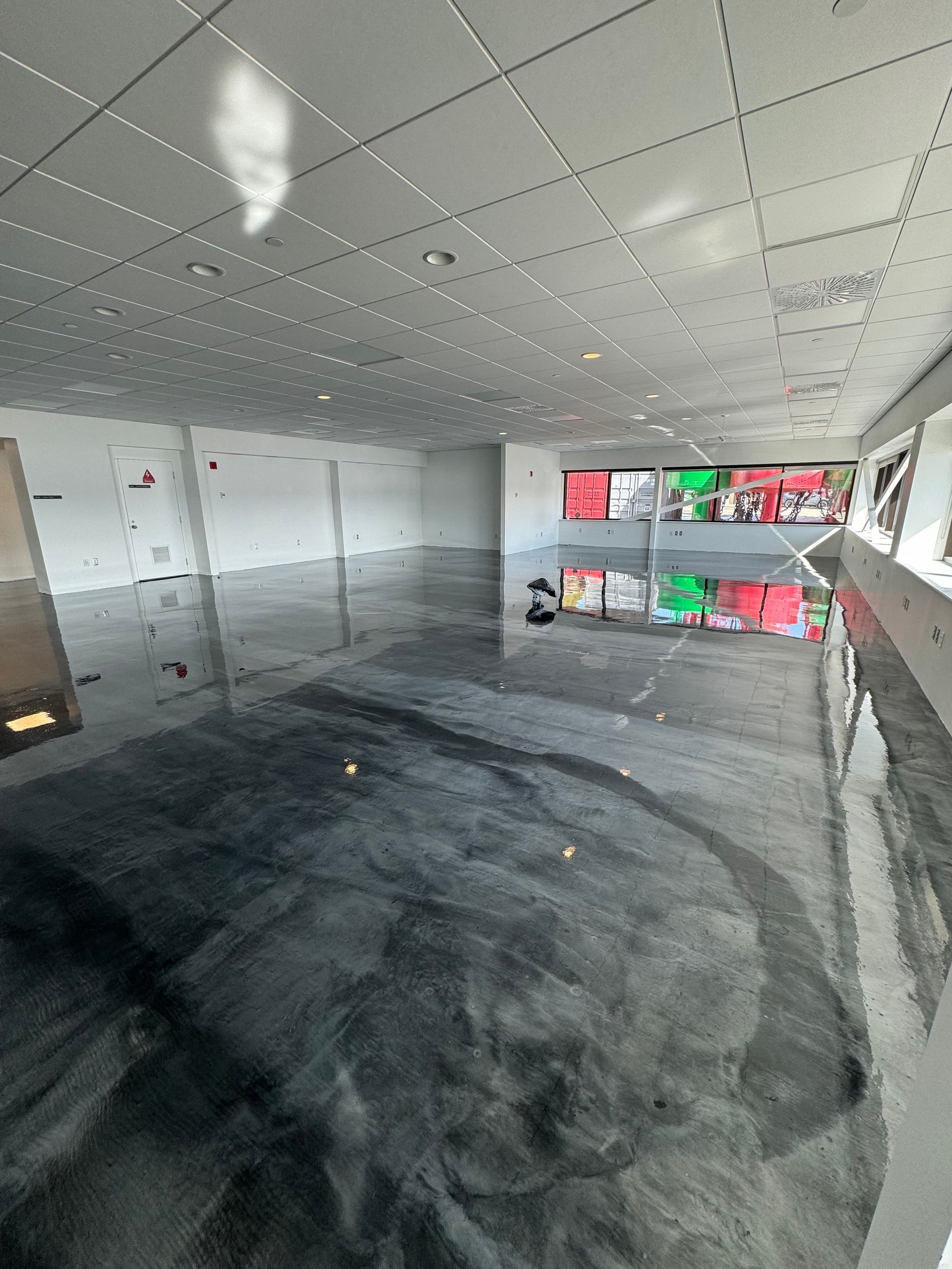 Une grande pièce avec un sol noir et un plafond blanc.
