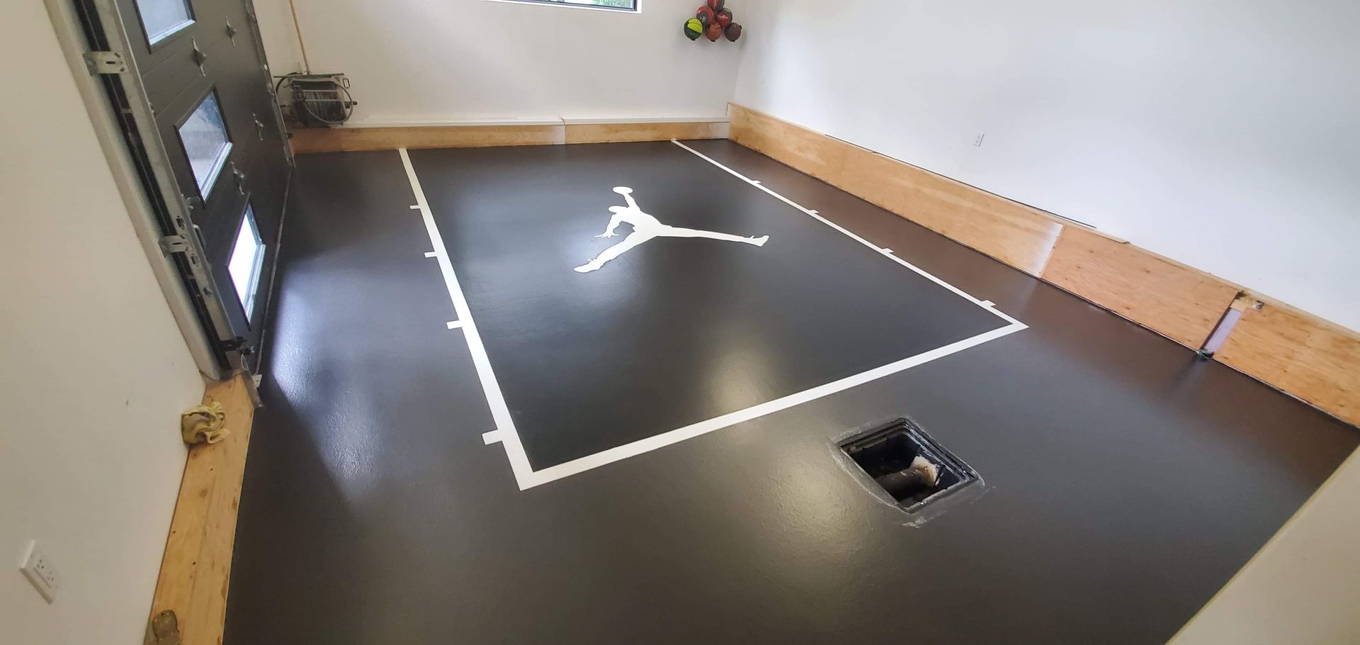 Un terrain de basket est peint sur le sol d'un garage.