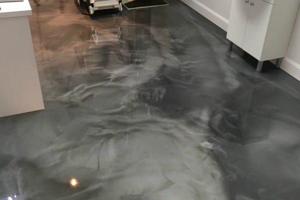 Un sol métallique brillant dans une pièce avec une armoire blanche.