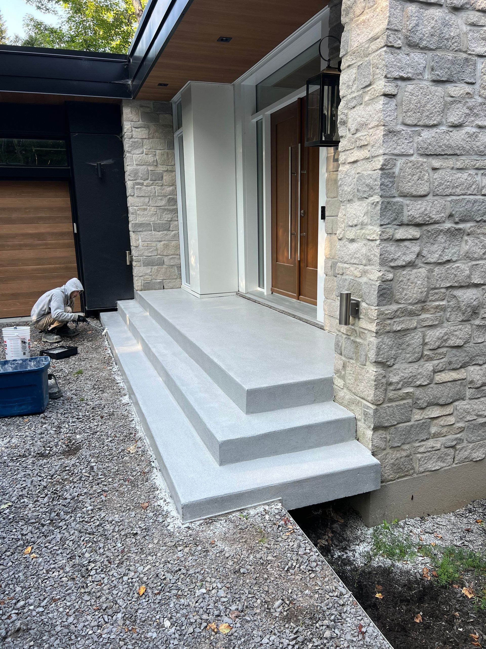 Un homme travaille sur le porche d'une maison.