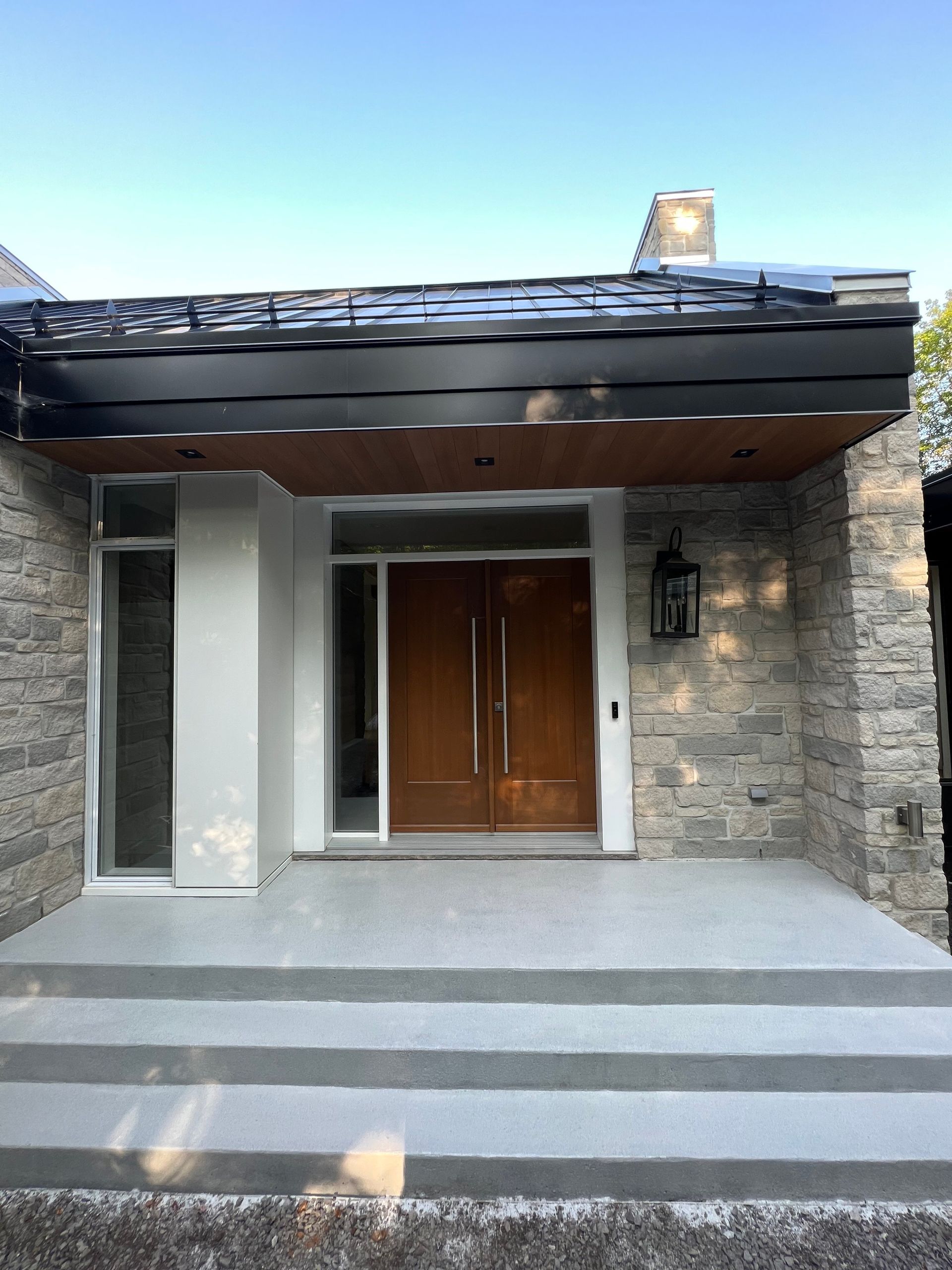 Une maison en pierre avec une porte et des marches en bois
