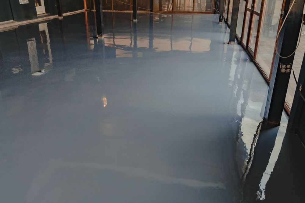 Sol en époxy gris reflétant l'espace intérieur avec fenêtres.