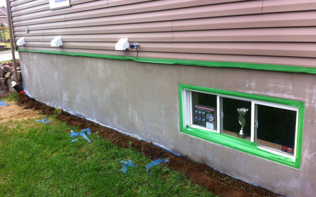 Une maison avec une fenêtre et une bordure verte est en train d'être peinte.