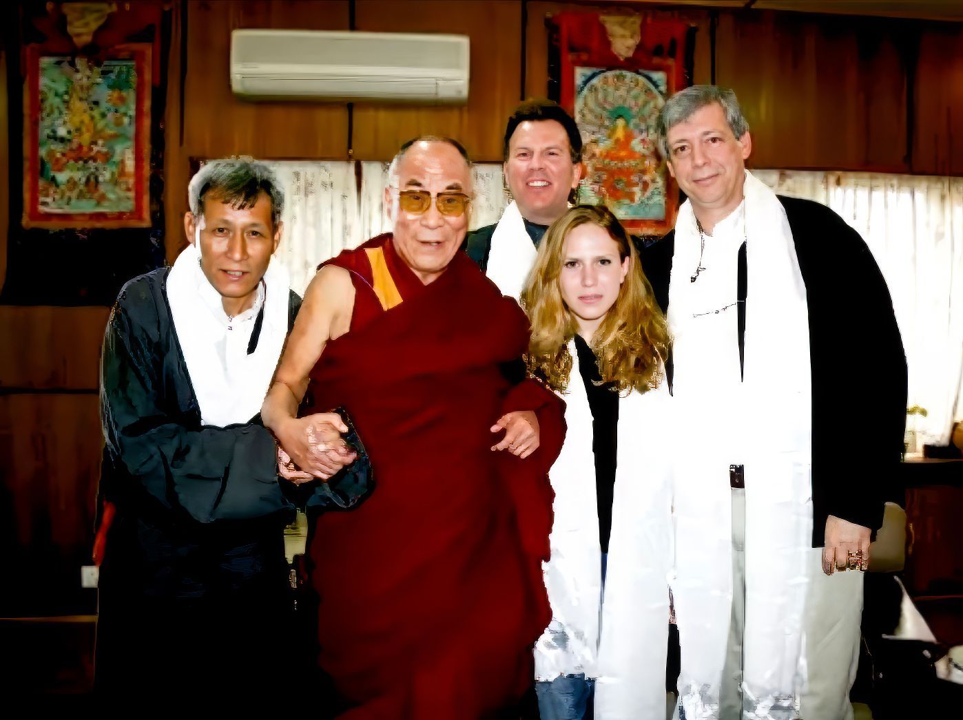 a group of people posing for a picture with a man in a red robe