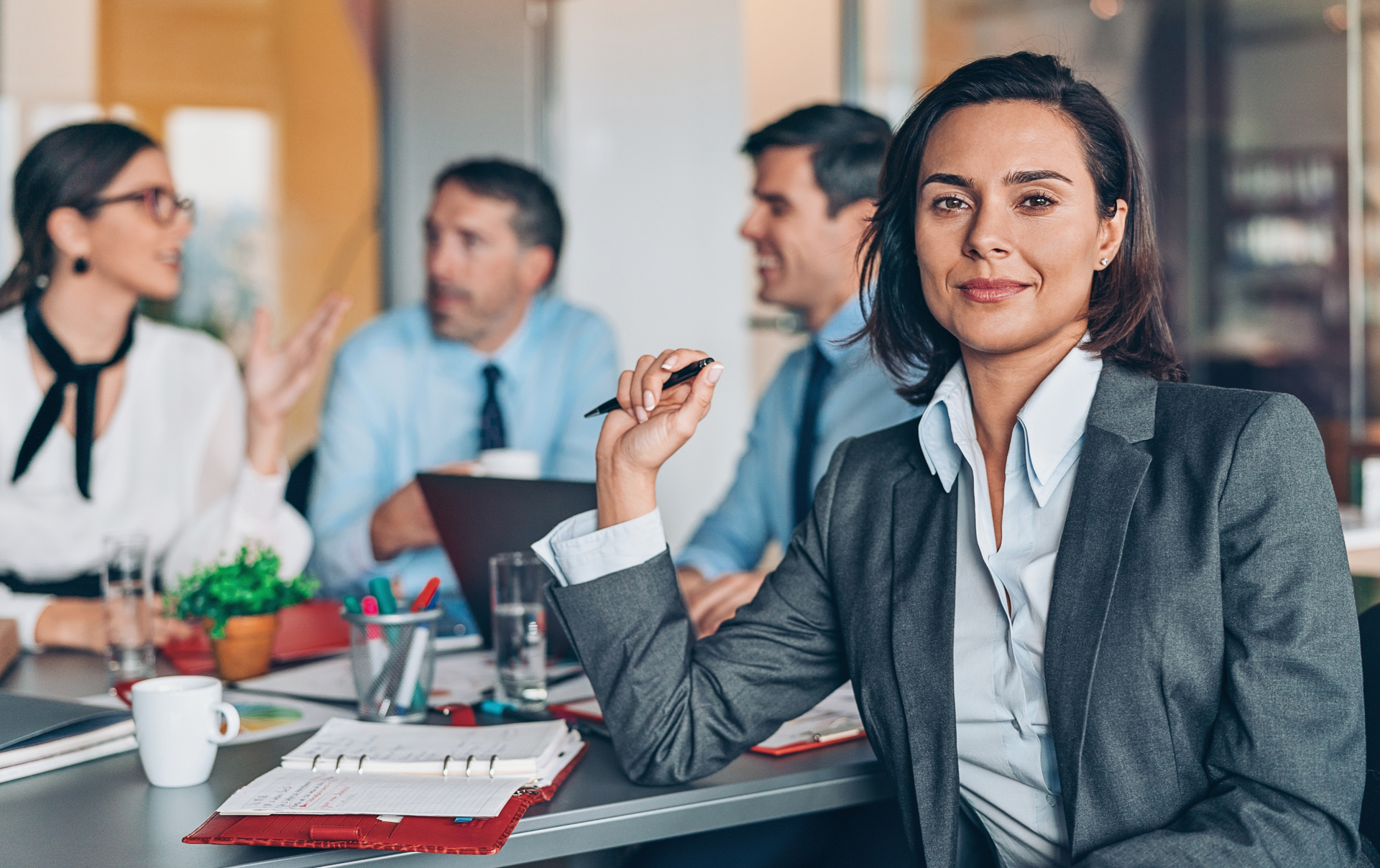 a woman is sitting at a table in front of a group of people .
