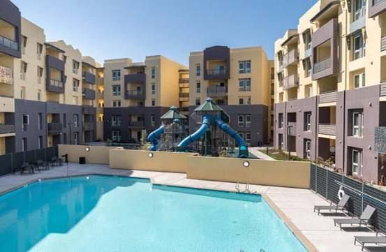 Steel frame construction of a building with exposed beams and a partially built roof against a blue sky.
