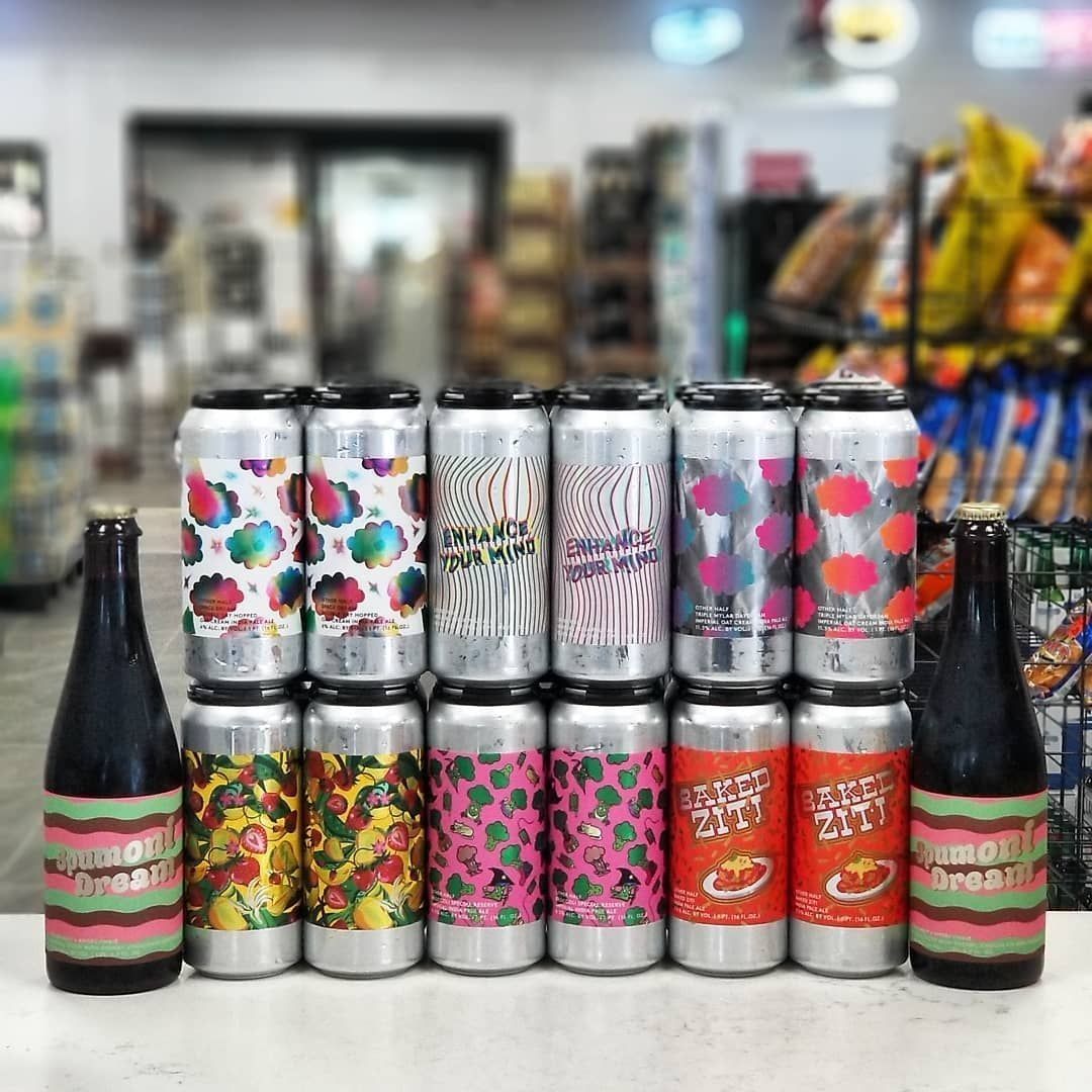 Rows of beer cans and bottles with colorful labels displayed in a store setting.