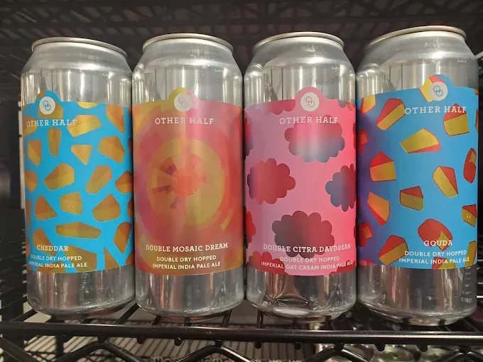 Four clear beer cans with colorful labels: blue, orange, pink, and blue, featuring abstract food designs.