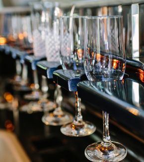 A row of wine glasses sitting on top of a bar.