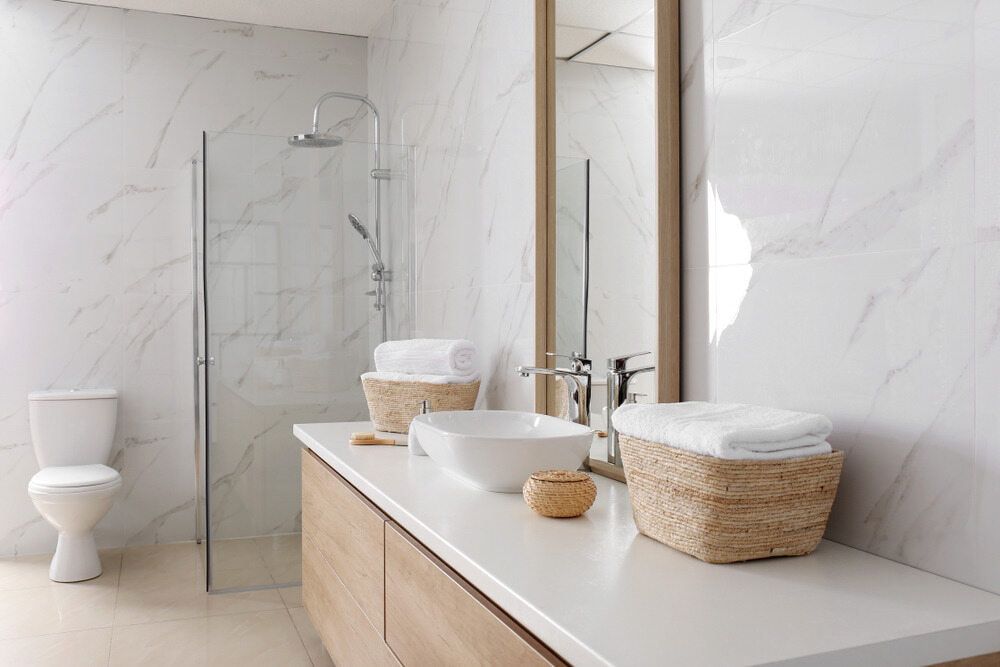A Bathroom With a Toilet, Sink, Mirror and Shower — Northern Tile Gallery in Winnellie, NT