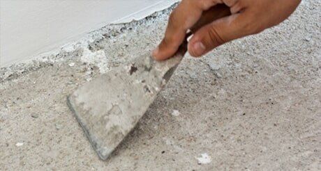 A Person is Holding a Spatula Over a Concrete Surface — Northern Tile Gallery in Winnellie, NT
