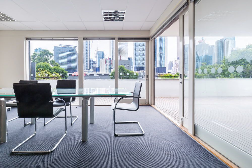 A Conference Room With a Glass Table and Chairs — Northern Tile Gallery in Winnellie, NT