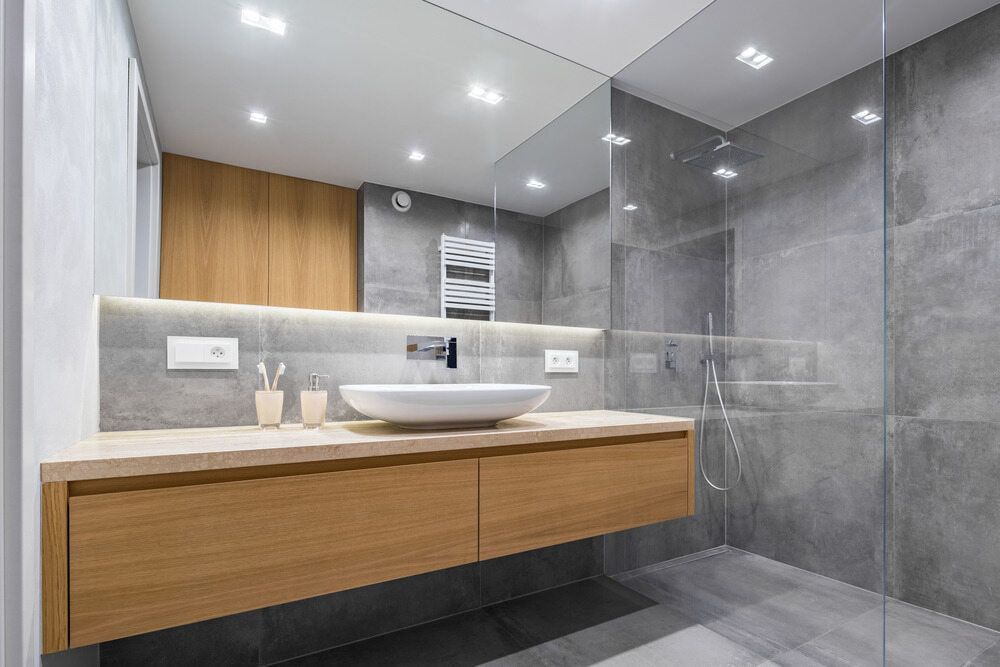 A Bathroom With a Sink,  Mirror and Walk in Shower — Northern Tile Gallery in Winnellie, NT