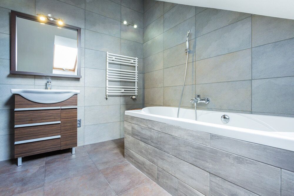 A Bathroom With a Bathtub, Sink, Mirror and Towel Rack — Northern Tile Gallery in Winnellie, NT