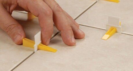 A Person is Using Tile Spacers to Level a Tile Floor — Northern Tile Gallery in Winnellie, NT
