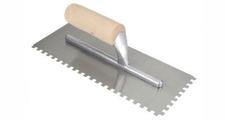A Stainless Steel Trowel With a Wooden Handle on a White Background — Northern Tile Gallery in Winnellie, NT