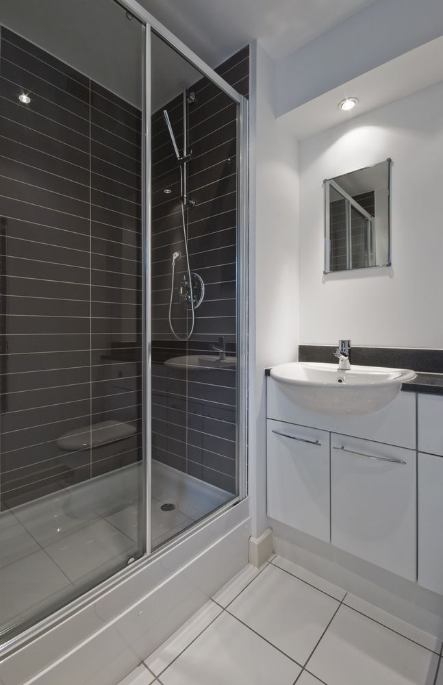 A Bathroom With a Shower, Sink and Mirror — Northern Tile Gallery in Winnellie, NT