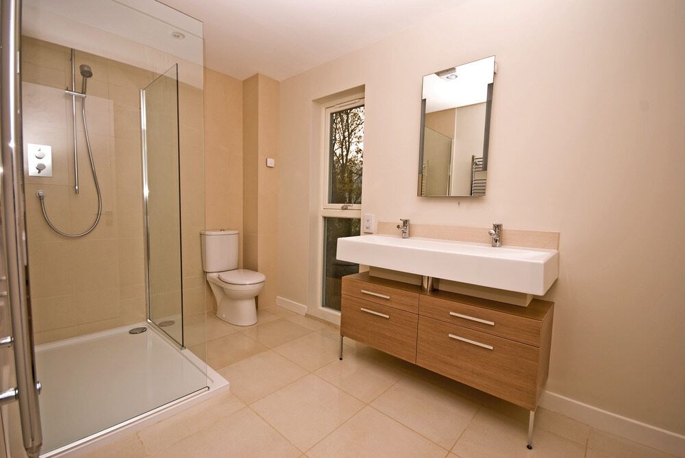 A Bathroom With a Toilet, Sink, Mirror and Walk in Shower — Northern Tile Gallery in Winnellie, NT
