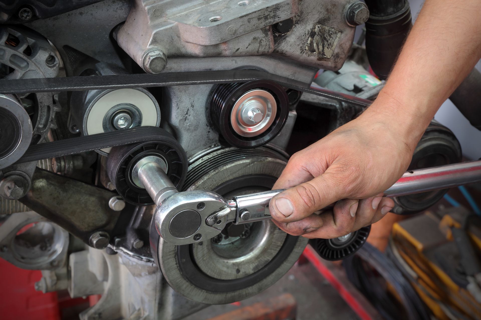 Hand using a wrench to tighten a motorcycle engine bolt close-up Hand using a wrench to tighten a motorcycle engine bolt close-up