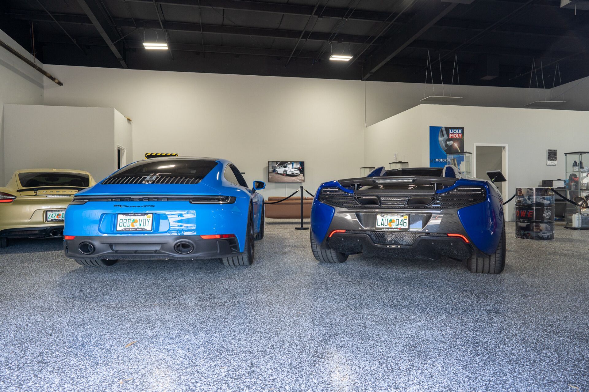 Two blue sports cars are parked in a garage | Adler Rennsport